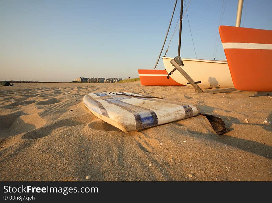 Catamaran & surfboard on beach