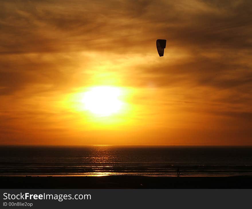 Kite Surfer on a beach at sunset near Melkbosstrand, Cape Town, on the South African West Coast. Kite Surfer on a beach at sunset near Melkbosstrand, Cape Town, on the South African West Coast