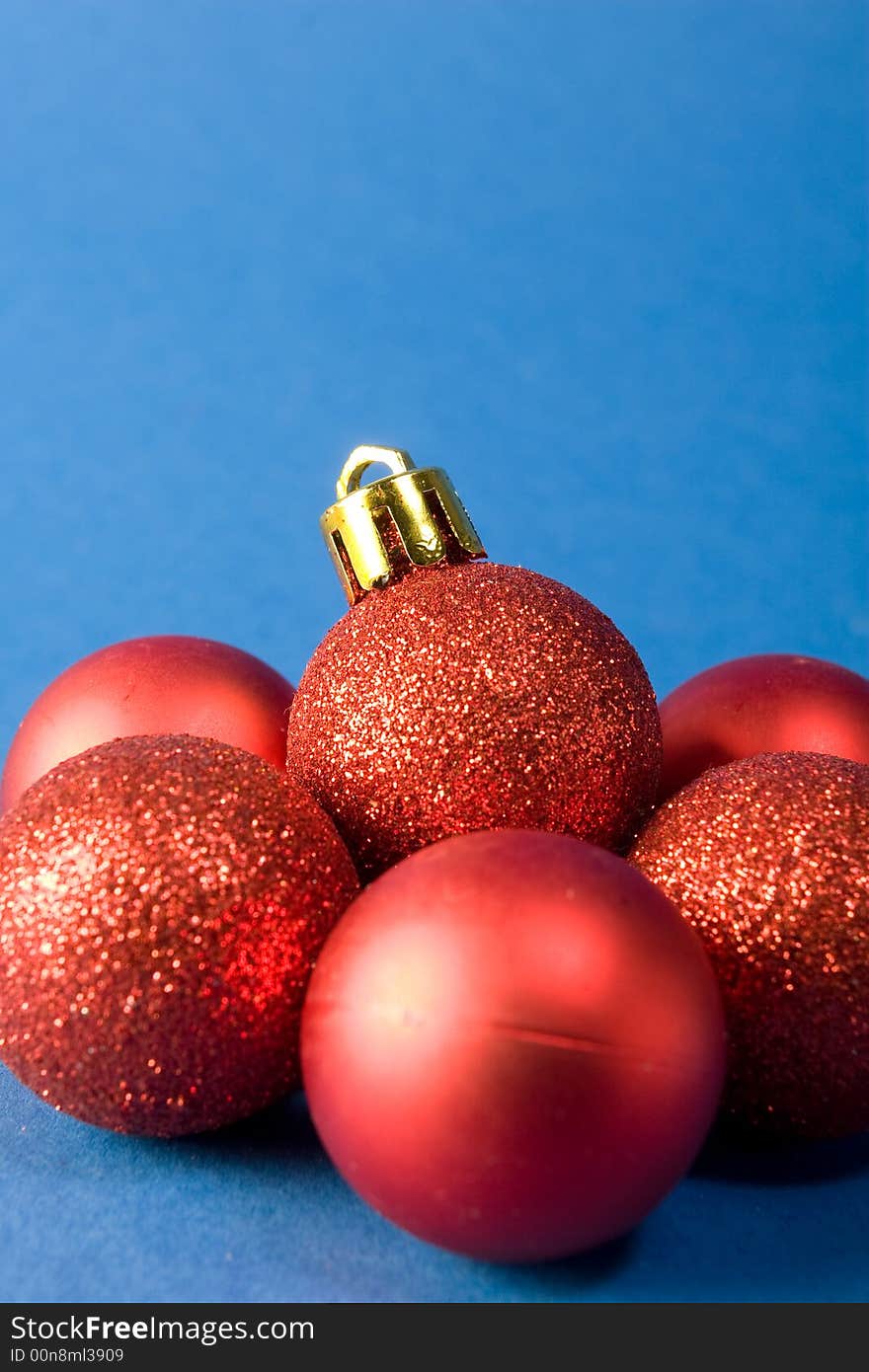 Group of small red christmas globes on blue background. Group of small red christmas globes on blue background