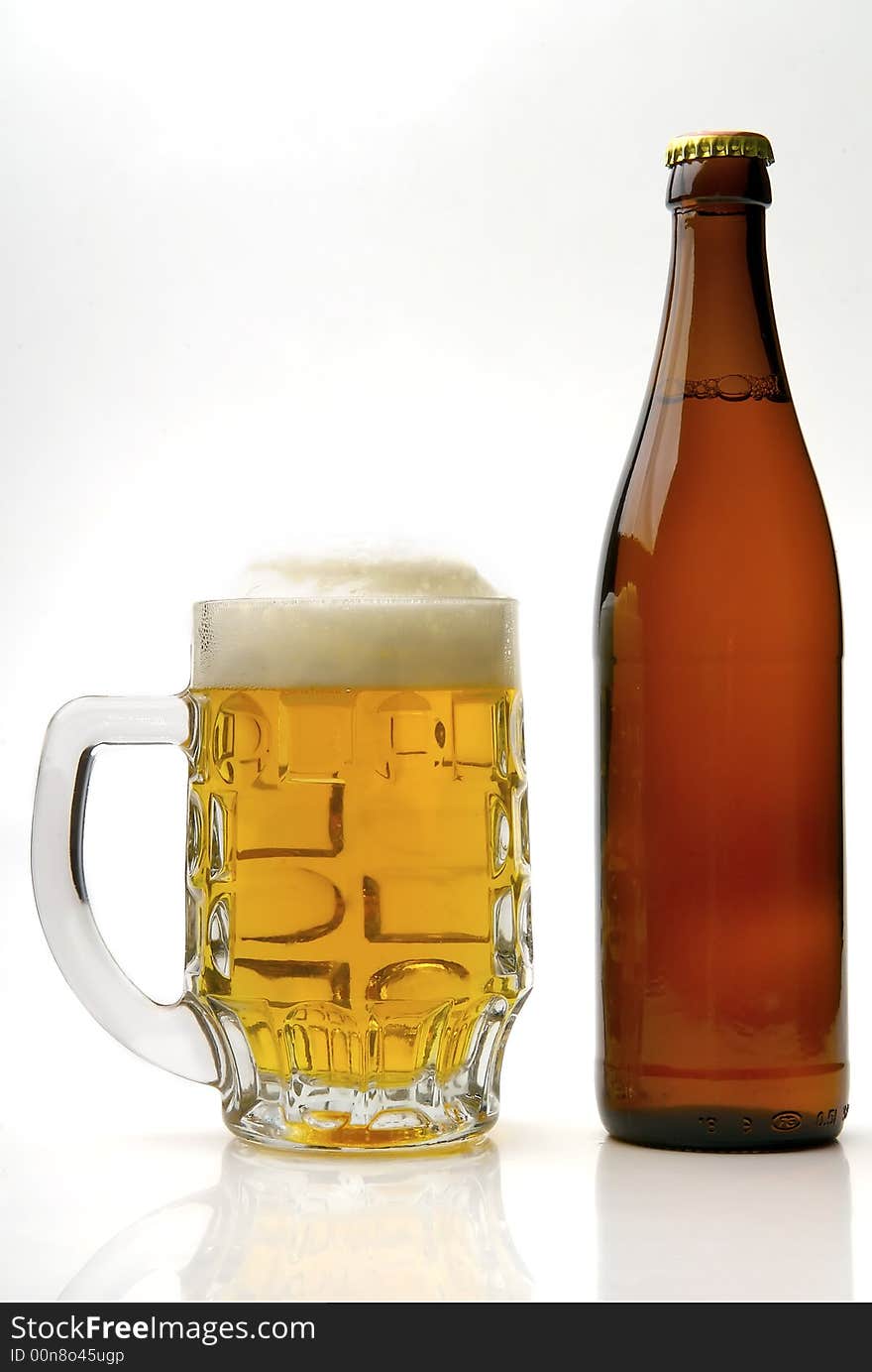 Fresh golden beer in a mug on a white background