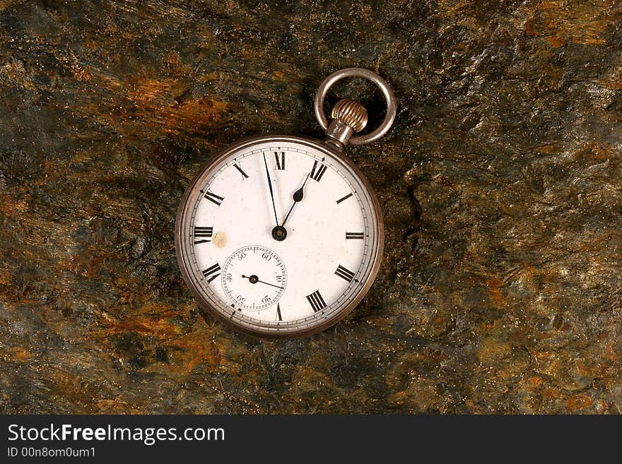 Antique pocket watch on rock