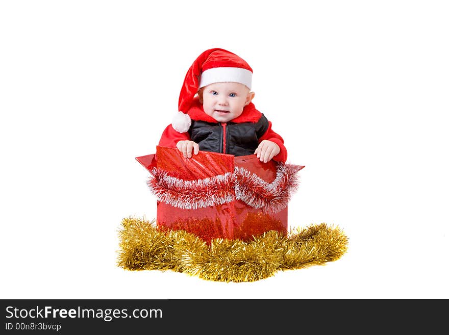 Happy infant with red cap in a decorated christmas box. Happy infant with red cap in a decorated christmas box