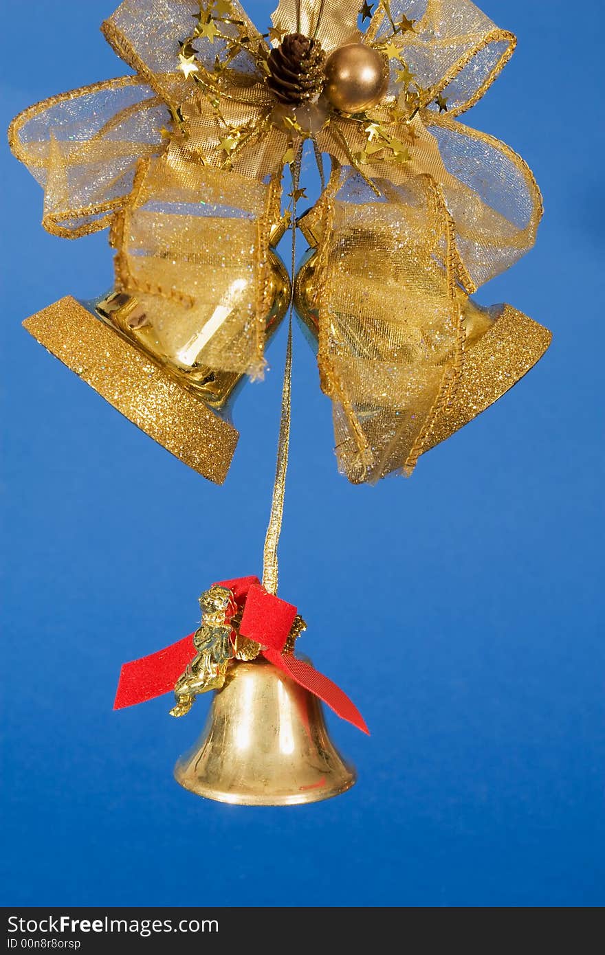 Golden bells and decorative ribbon on blue background. Golden bells and decorative ribbon on blue background