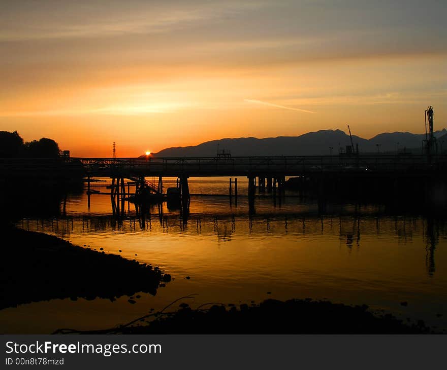 Intense orange sunset over a rock beach in Vancouver.