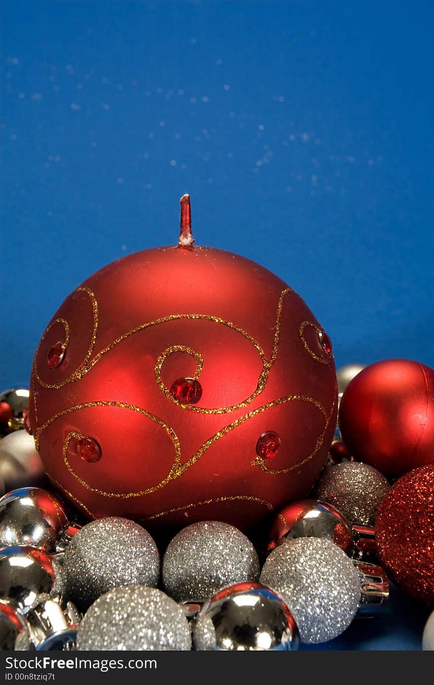 Big red christmas candle and small globes. Big red christmas candle and small globes