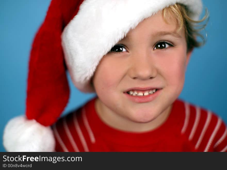 A young boy wearing a santa hat, smiling