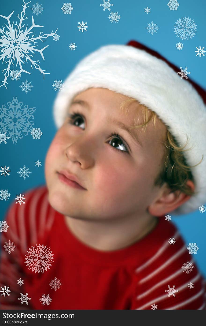 Young Boy In A Santa Hat Looking At Snowflakes