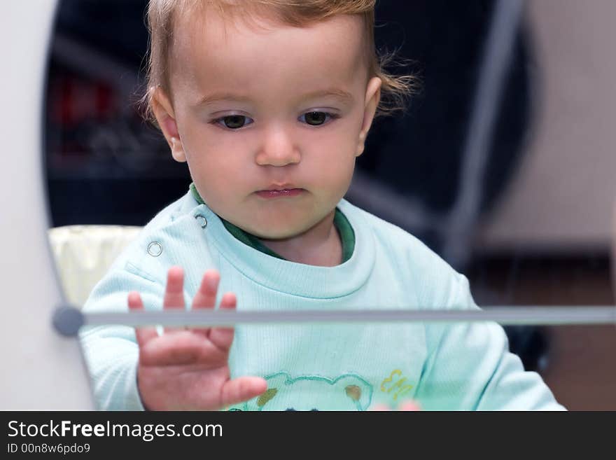 Small children watching himself in the mirror. Small children watching himself in the mirror