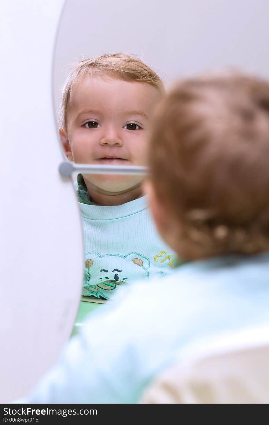 Cute young boy looking himself in the mirror. Cute young boy looking himself in the mirror