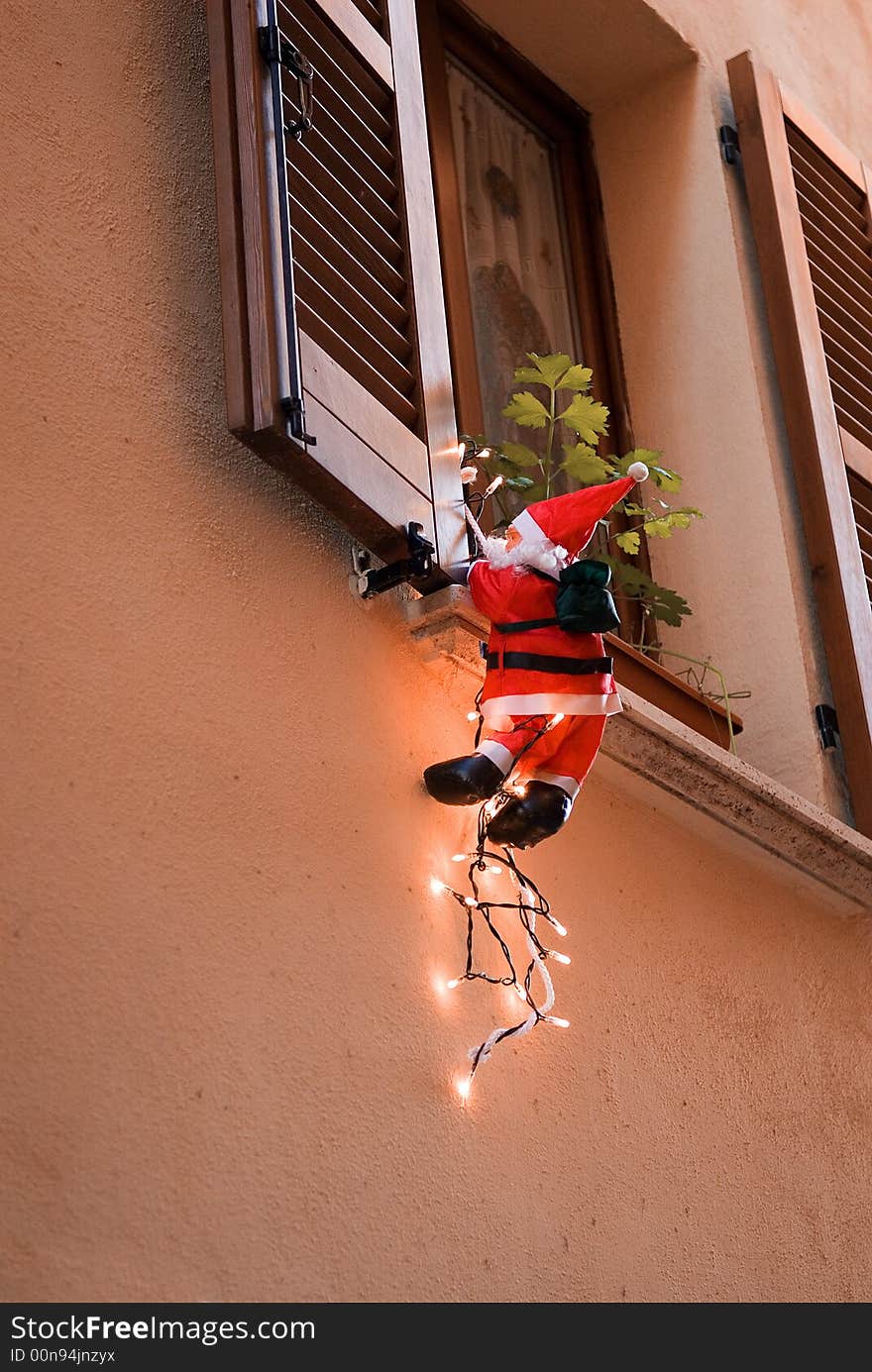 Santa Clause entering home through a window. Santa Clause entering home through a window