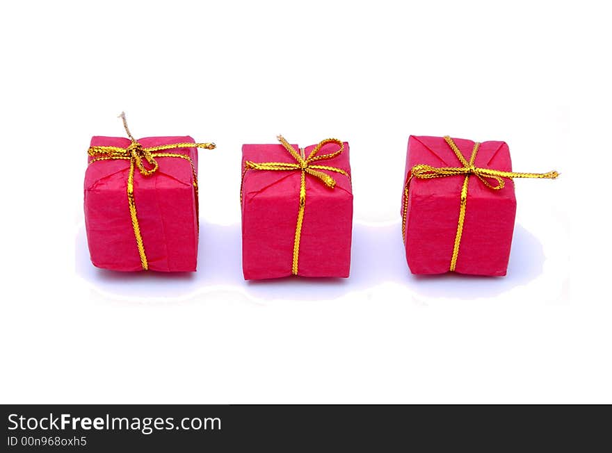 Three christmas gift boxes with golden ribbons isolated on white. Three christmas gift boxes with golden ribbons isolated on white