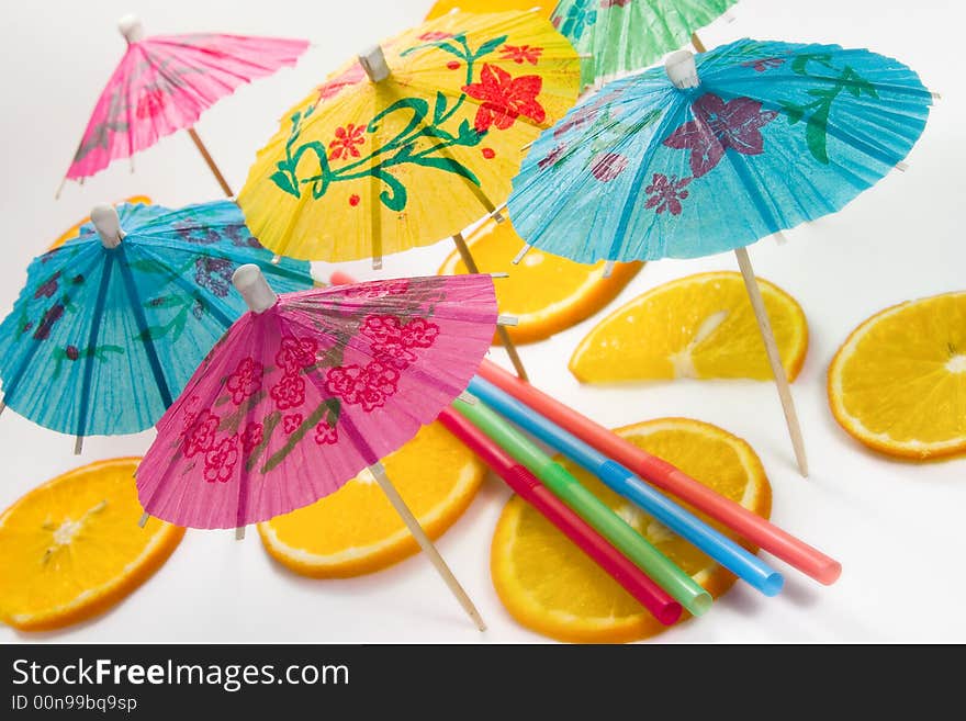 Straw, slices of  orange and decorative umbrellas. Straw, slices of  orange and decorative umbrellas