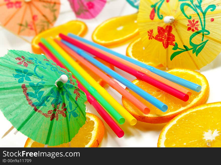 Straw, slices of orange and decorative umbrellas. Straw, slices of orange and decorative umbrellas