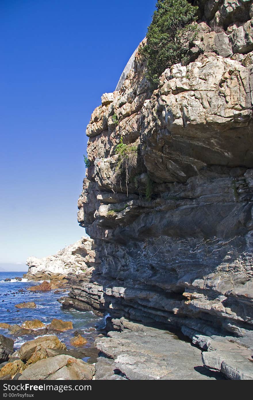 Rocky coastline of Hermanus South Africa with blue skies. Rocky coastline of Hermanus South Africa with blue skies