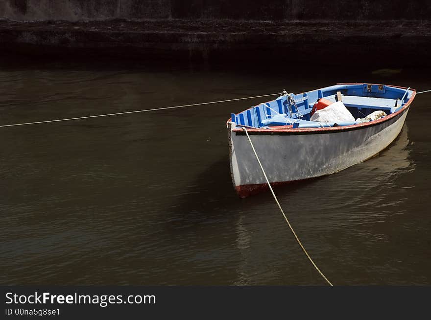 Small fishing rowboat moored at harbour