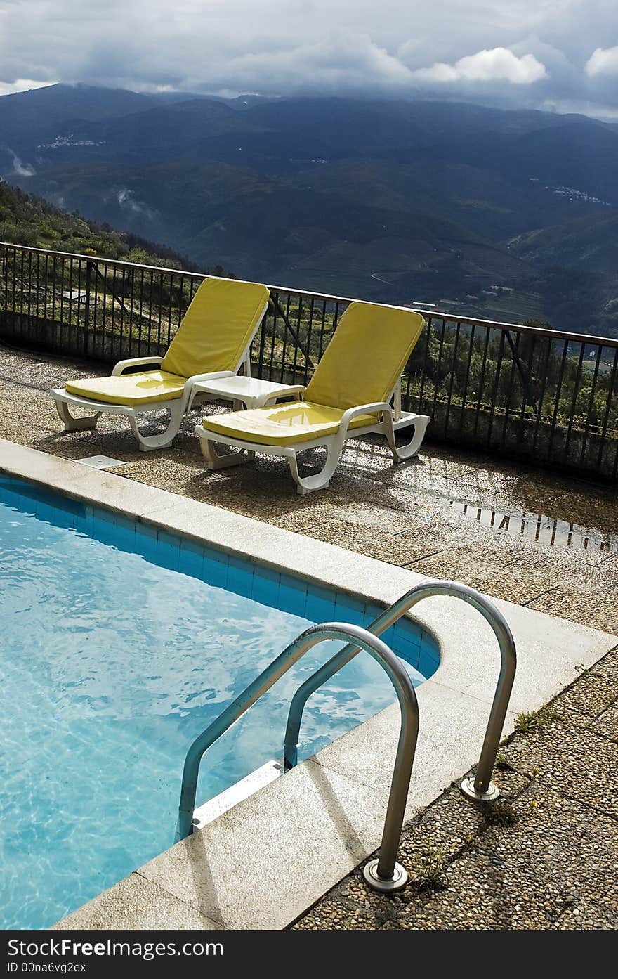 Long chairs by the pool in a mountain landscape. Long chairs by the pool in a mountain landscape