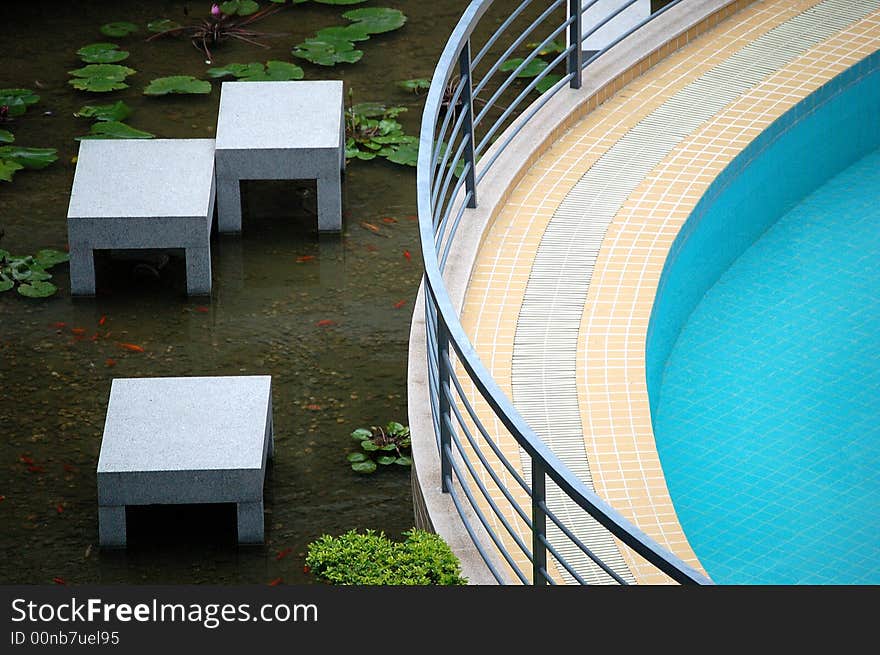 Part of a swimming pool with a beautiful pond beside it, shot at a hotel in Longsheng, Guilin City, China.