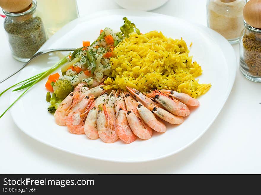 Tasty rice, shrimps and vegetables on the white plate. Eastern cuisine