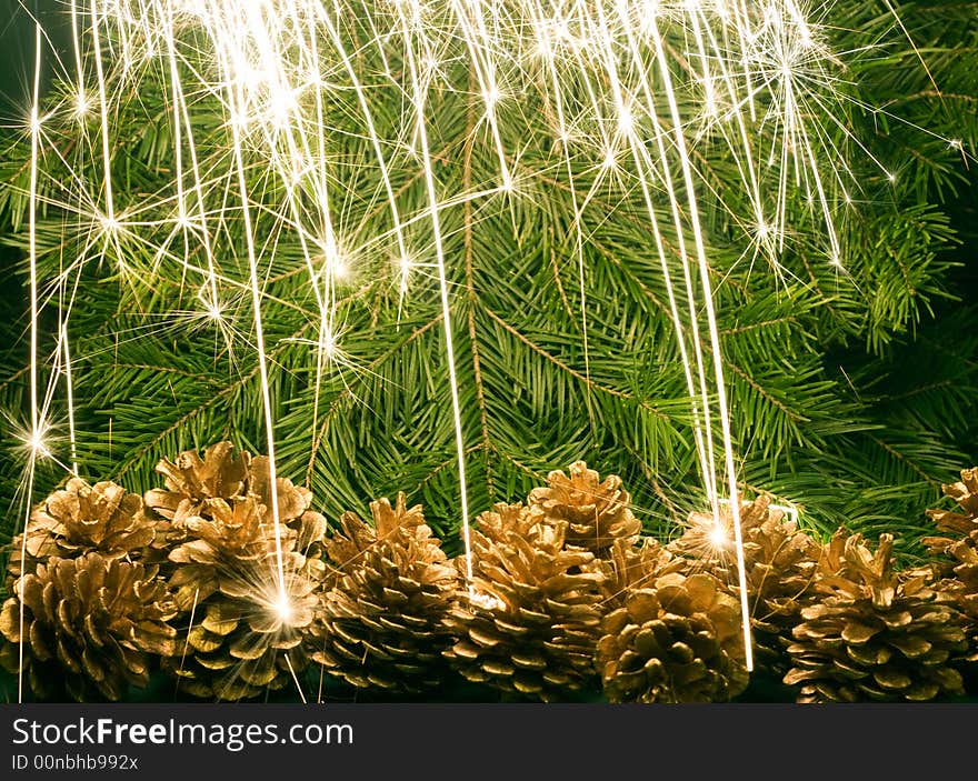 Christmas tree background, cones and sparkles of Bengal light. Christmas tree background, cones and sparkles of Bengal light