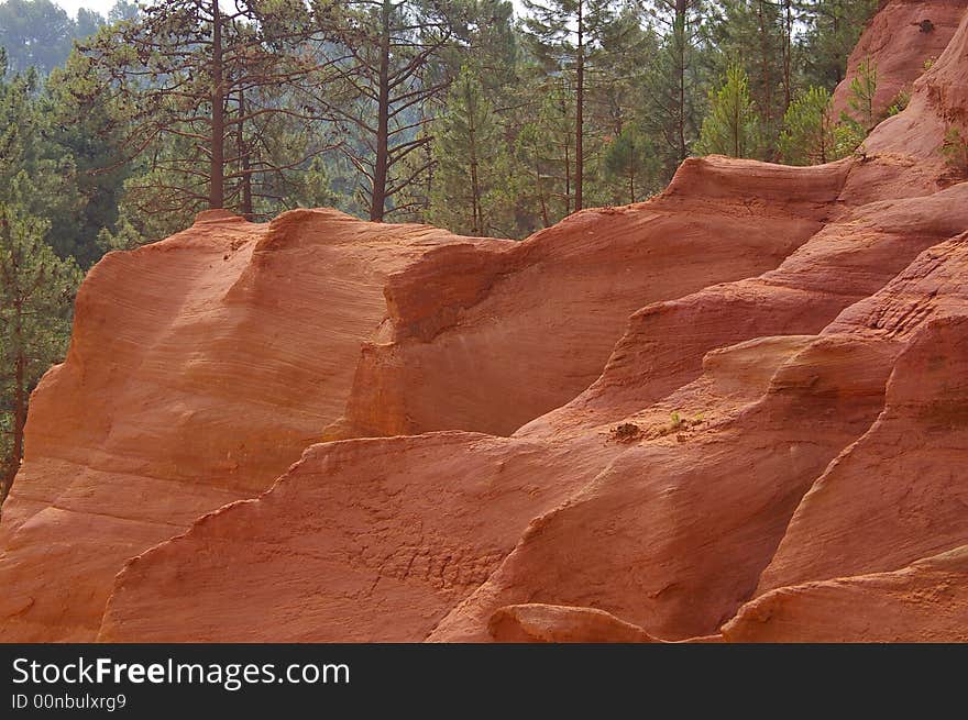 Geological landscape composed by a red rock sculpted by erosion in first plan and pine wood in background
It is in the south of France, a place called Luberon. Geological landscape composed by a red rock sculpted by erosion in first plan and pine wood in background
It is in the south of France, a place called Luberon.