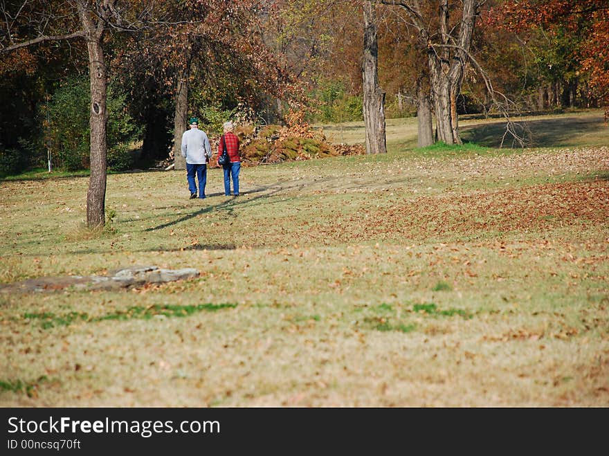 Older couple walks in park on autumn day. Older couple walks in park on autumn day