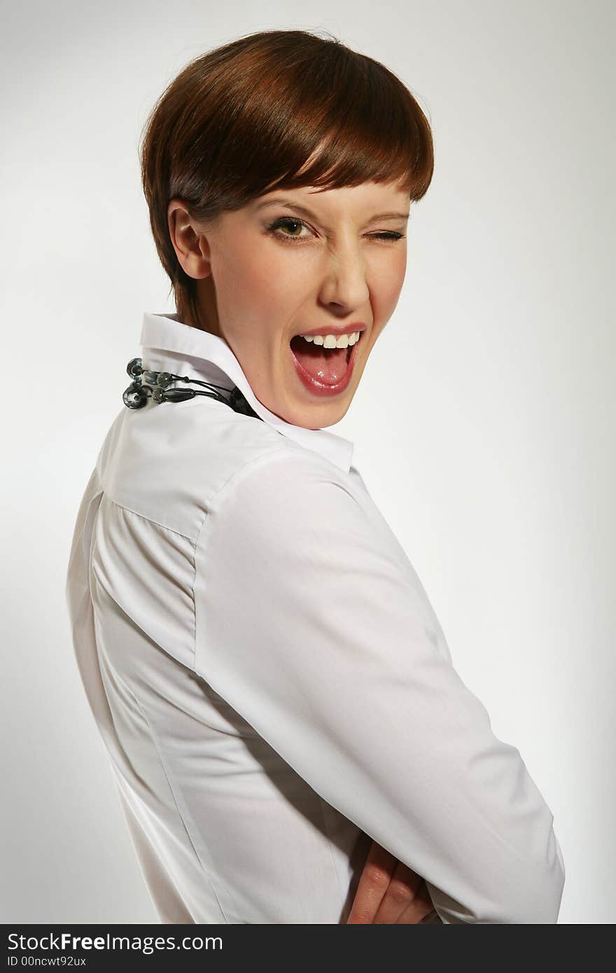 Young brunette businesswoman winking in front of the white background