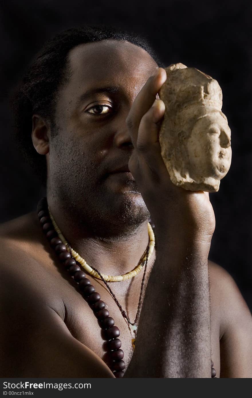 Afroamerican man holding buddha stone figurine. Afroamerican man holding buddha stone figurine