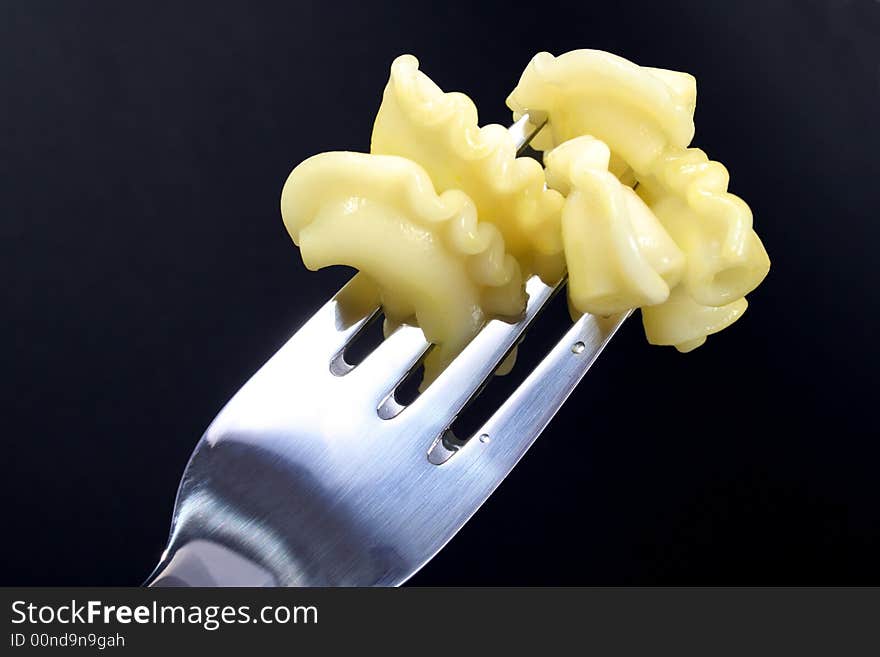 PASTA ON FORK ON BLACK BACKGROUND