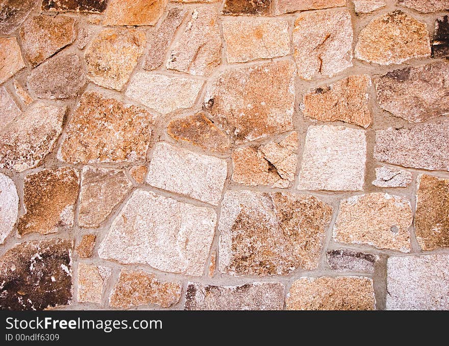 A granite stone wall of brightly colored  blocks. A granite stone wall of brightly colored  blocks