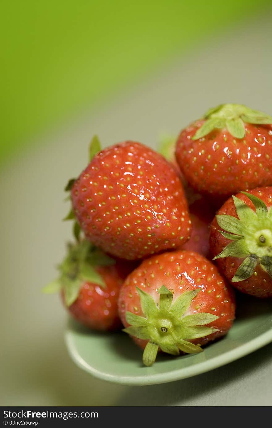 Dish of vivid and fresh strawberries on a table.