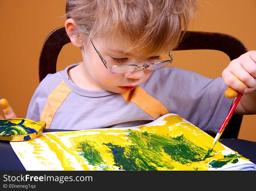 Little boy painting at easel