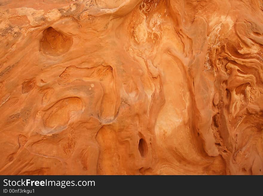 These fascinating patterns were etched into this red sandstone of a slot canyon wall by wind and water.  This is a good background or texture image. These fascinating patterns were etched into this red sandstone of a slot canyon wall by wind and water.  This is a good background or texture image.