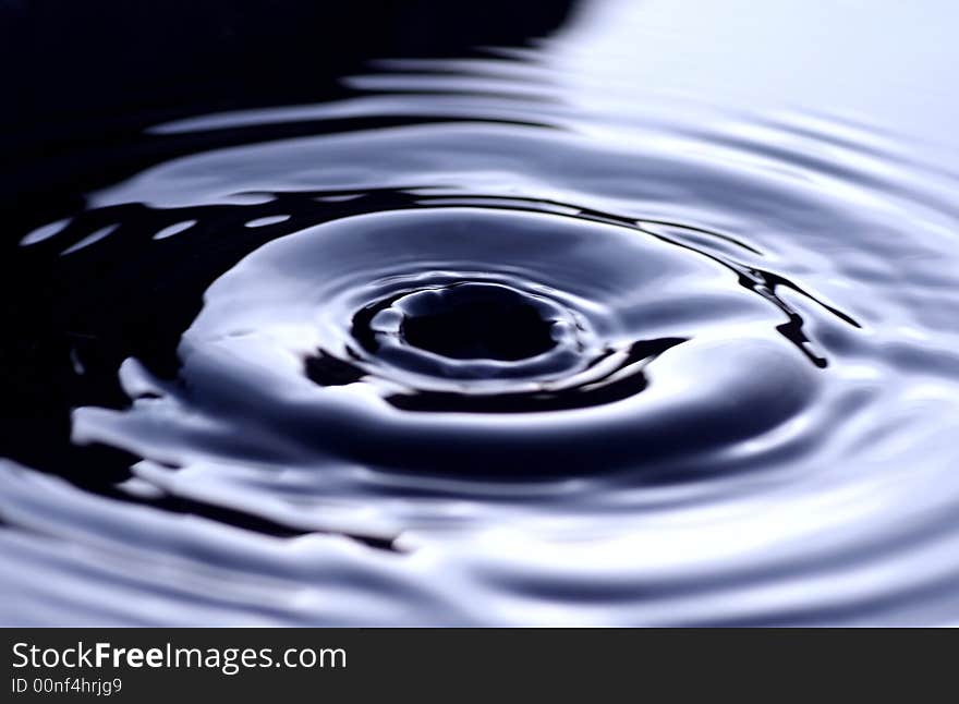 A drop of water knocks into the calm surface. A drop of water knocks into the calm surface