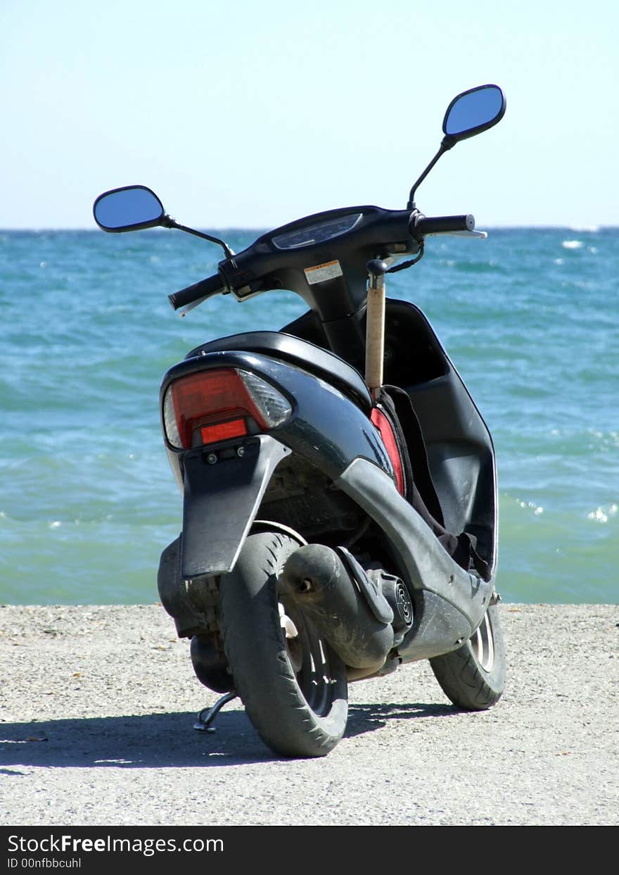 Motorbike on a mooring on a background of the blue sea