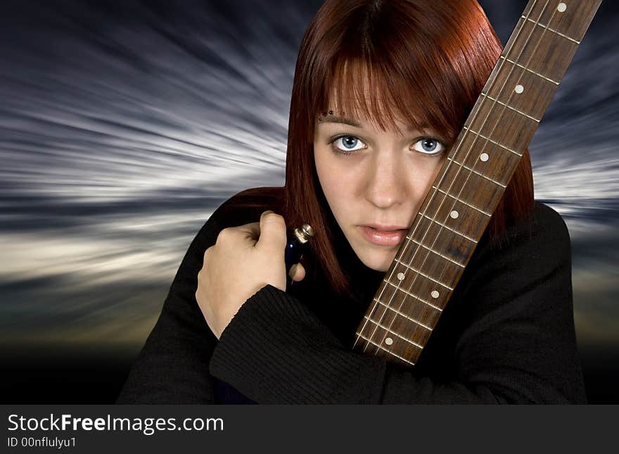 Depressed redhead girl protecting her guitar with a dramatic background. Depressed redhead girl protecting her guitar with a dramatic background.