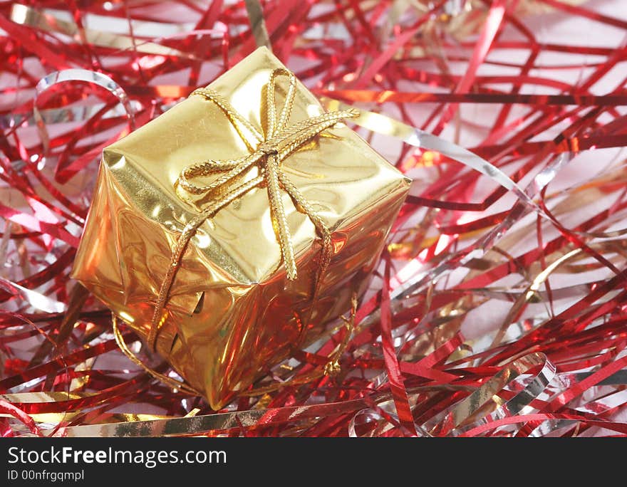 Gold gift box in red tinsel.