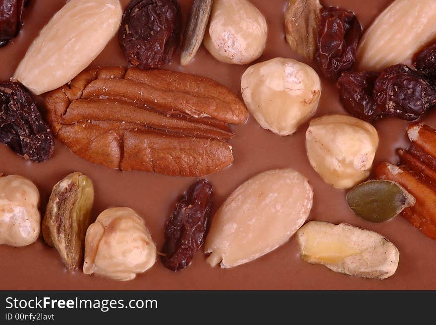 An assortment of nuts photographed in a studio. Handmade sweet made by putting mixed nuts in chocolate.