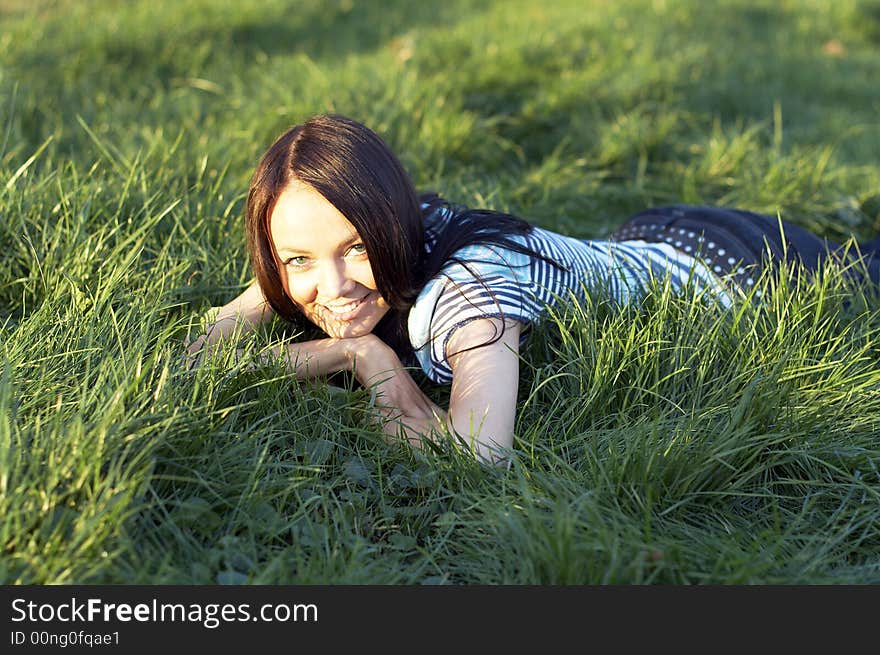 Teen girl lays on a grass