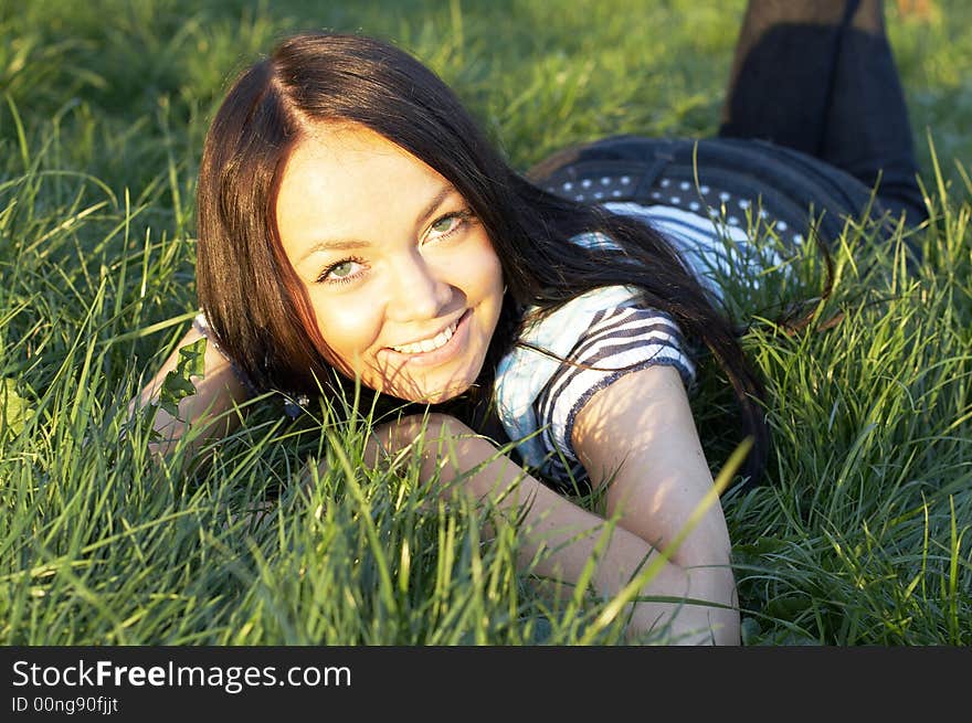 Teen girl lays on a grass