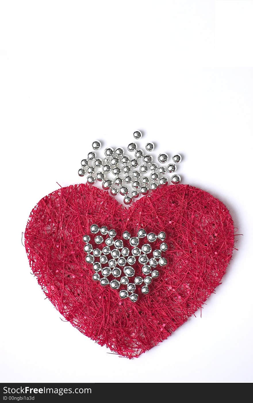 A piece of red fibre cloth forming an artificial pattern, in shape of a heart and with silver droplets on top. A piece of red fibre cloth forming an artificial pattern, in shape of a heart and with silver droplets on top