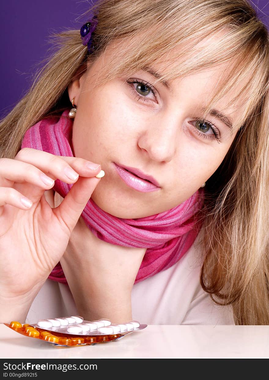 Portrait of beautiful woman with pill on the hand