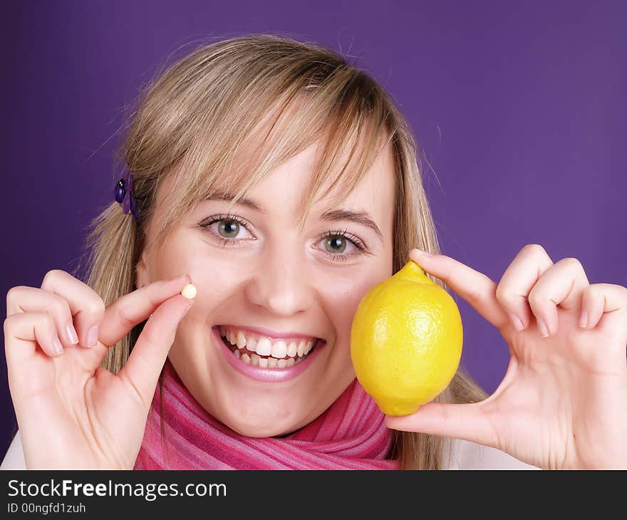 Smiling girl with lemon and pill on the hands. Smiling girl with lemon and pill on the hands