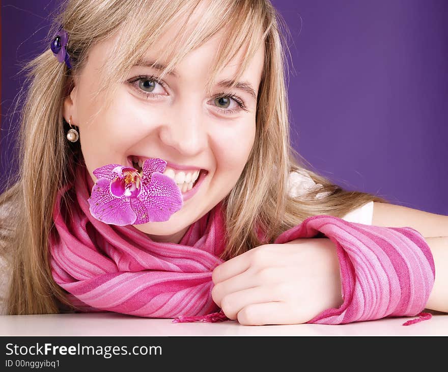 Young woman with orchid in mouth