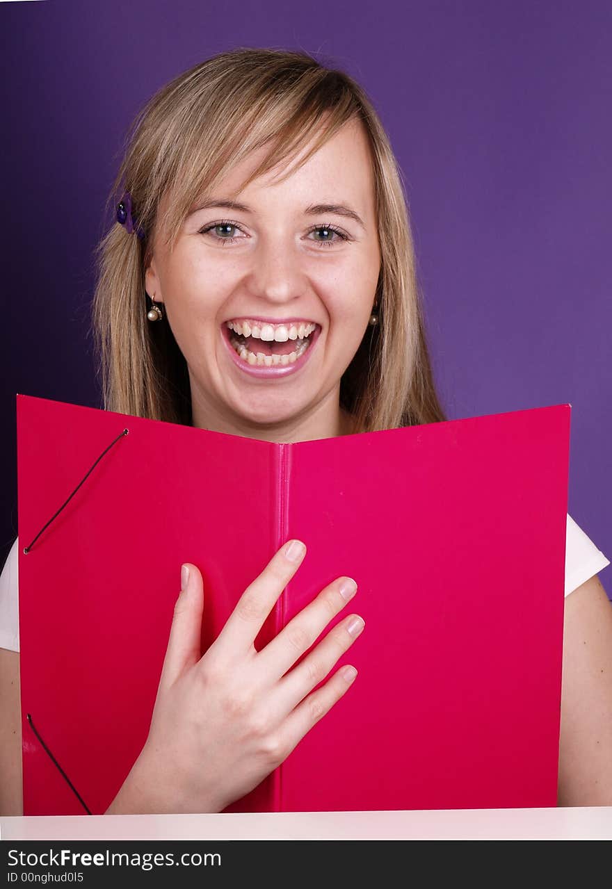 Smiling blond girl on the purple background.