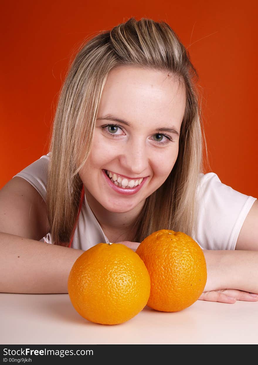 Young smiling woman with oranges.