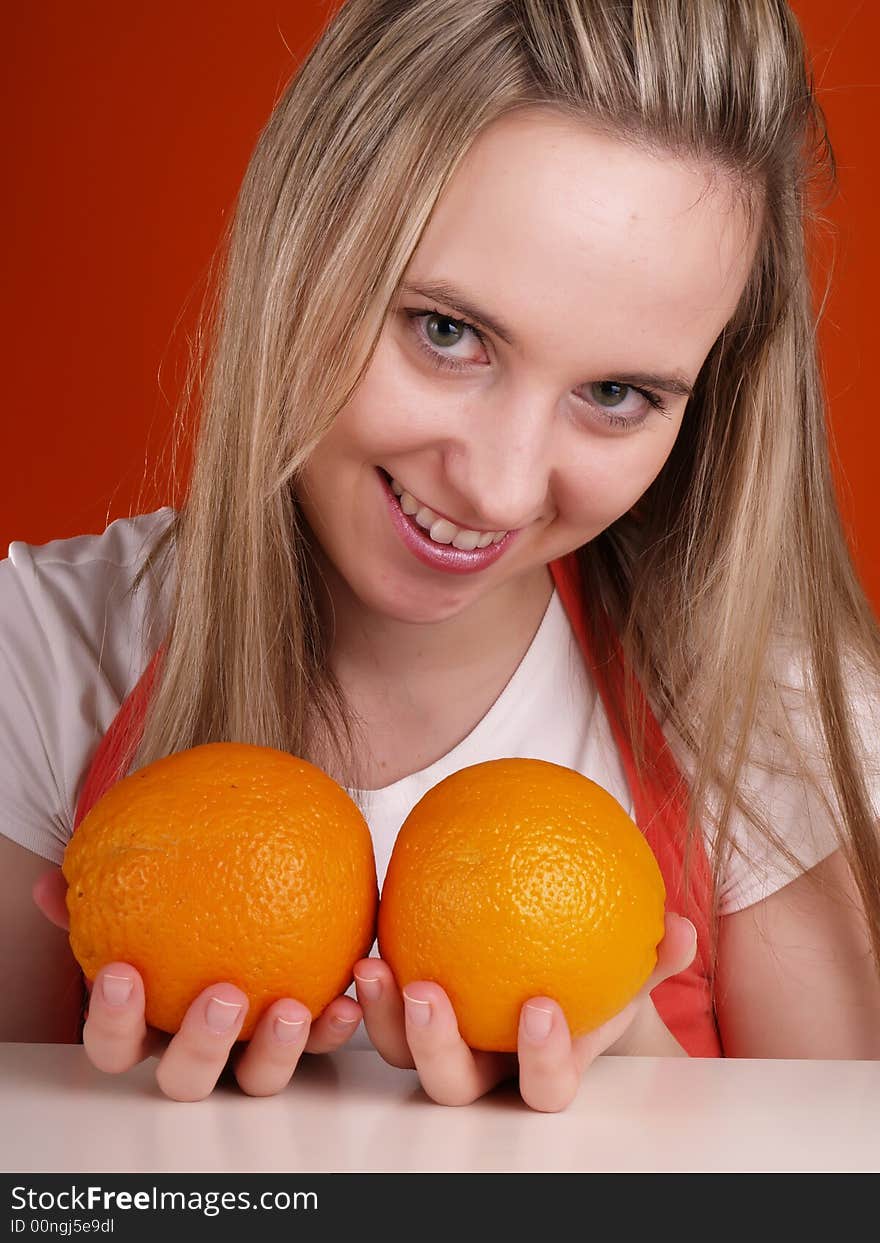 Beautiful woman with oranges in hands.