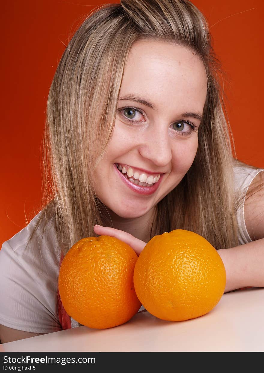 Smiling blond girl with oranges.