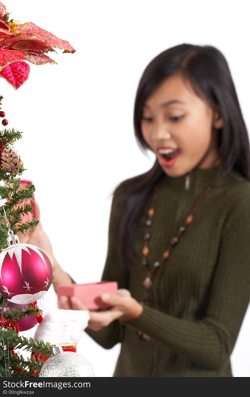 A surprised girl holding her christmas gift