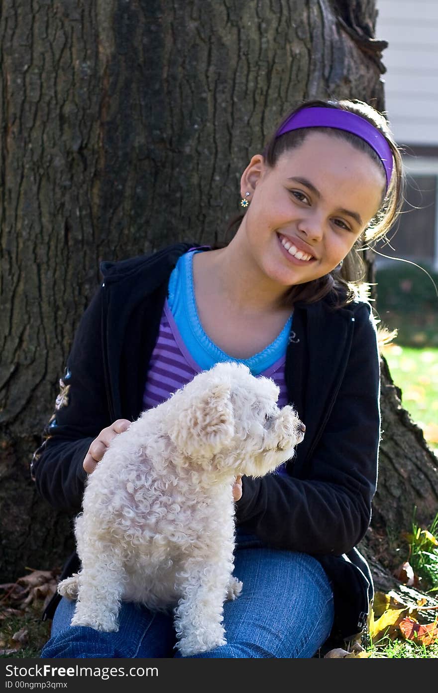 Young girl and poodle by tree