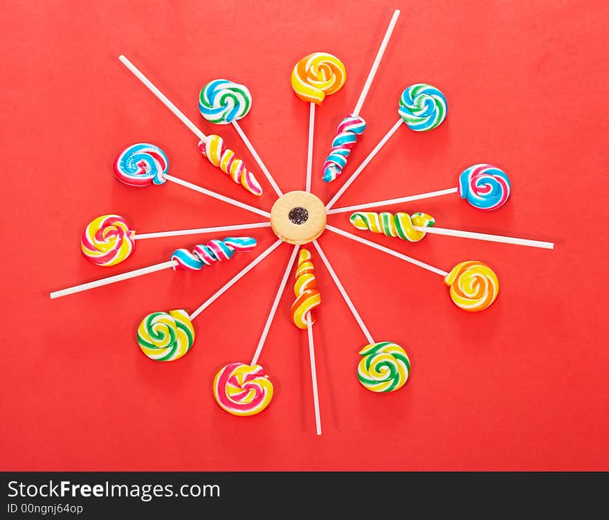 Twirl lollipop candies over a red background